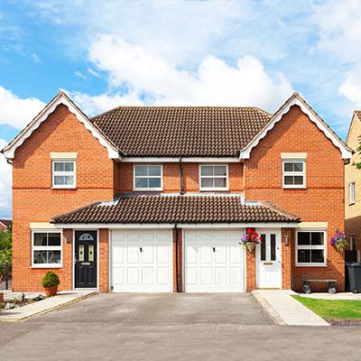 New build semi-detached houses with white garage doors.