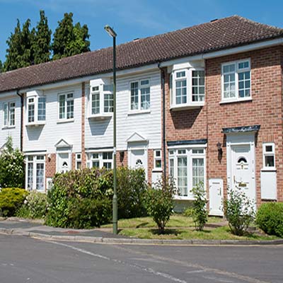 Row of modern terraced houses with shrubs growing in the front gardens