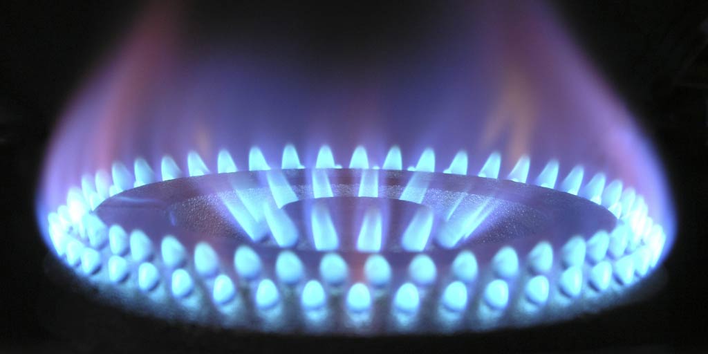 Close up of lit gas hob ring with high flame