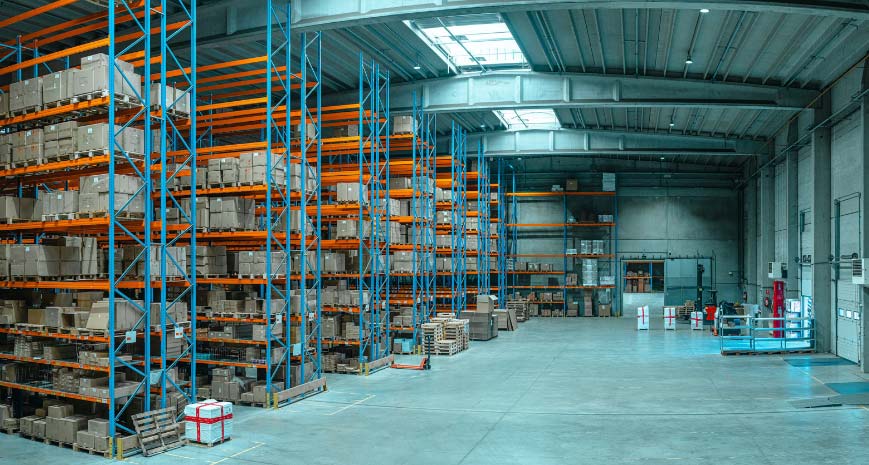 Large warehouse with blue racking and orange shelving, holding lots of cardboard boxes
