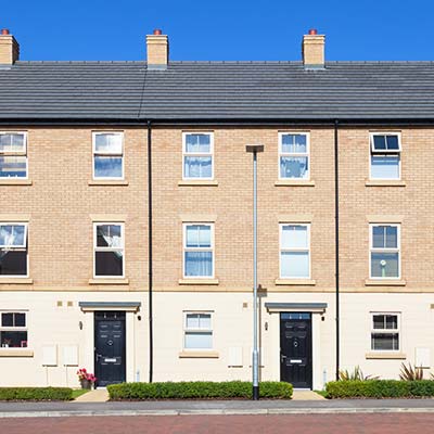 Modern three storey cream brick houses with a bright blue sky