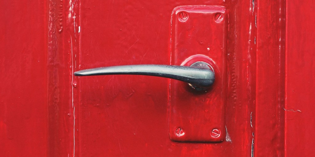 Red painted front door with part-painted, part metal-finish door handle