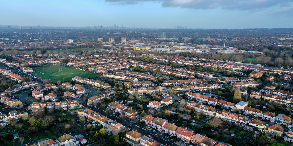 Aerial photo of London suburbs with Canary Wharf in far distance on horizon